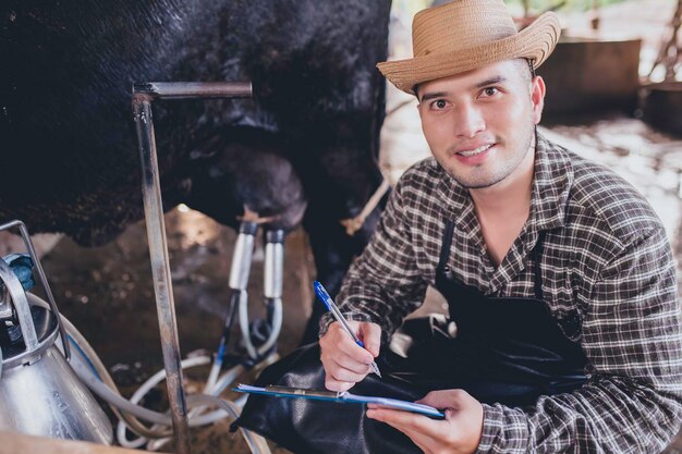 asian farmer work rural dairy farm outside cityyoung people with cow